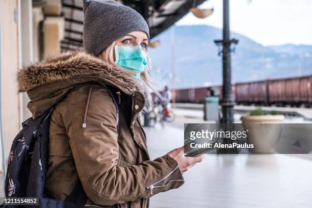kaukasiska kvinna kriga ansiktsmask på stationen - coronavirus winter bildbanksfoton och bilder