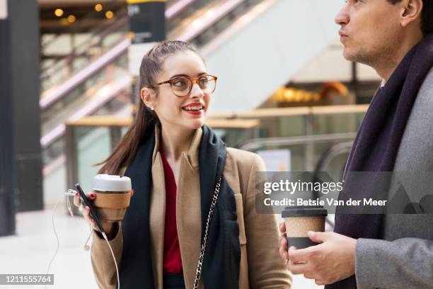 businesman and woman on the move, holding reusable coffeecups. - coffe to go stock pictures, royalty-free photos & images