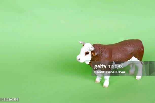 toy cow on green - 動物のおもちゃ ストックフォトと画像