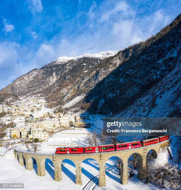 bernina train passes over the helical viaduct of brusio. - brusio grisons stock pictures, royalty-free photos & images