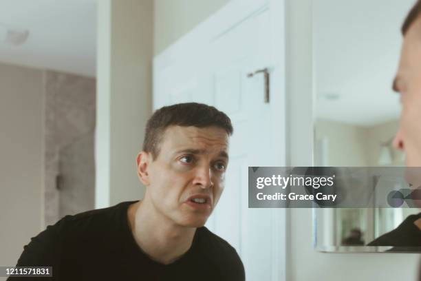 man looks into mirror with disgust - offense stock pictures, royalty-free photos & images