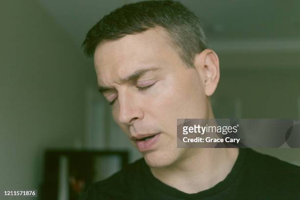 close-up portrait of man with eyes closed - annoyed face brunnette stock-fotos und bilder