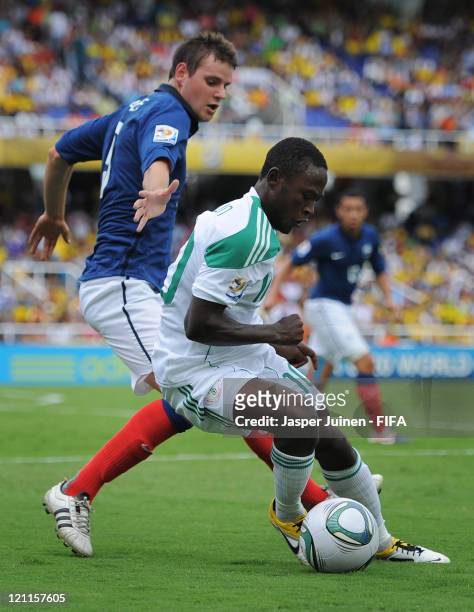 Abdul Ajagun of Nigeria duels for the ball with Sebastien Faure of France during the FIFA U-20 World Cup Colombia 2011 quarter final match between...