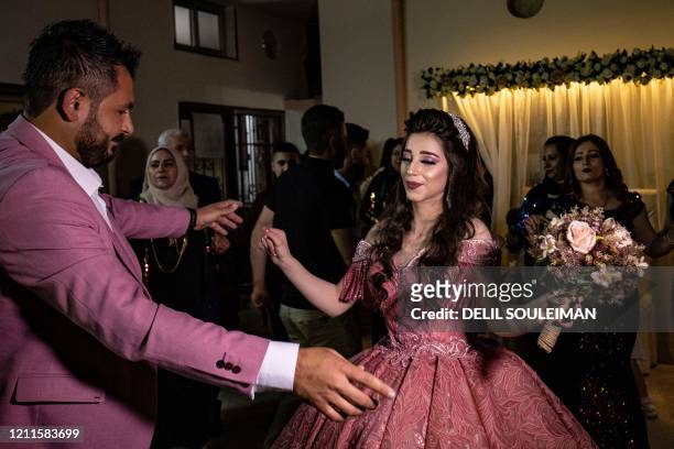 Syrian Kurdish couple Dilxwaz Ali and Arishan Ali dance during their engagement ceremony at home in the city of Qamishli in Syria's northeastern...