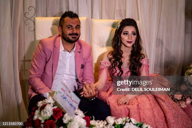 Syrian Kurdish couple Dilxwaz Ali and Arishan Ali pose for a picture during their engagement ceremony at home in Qamishli city in Syria's...