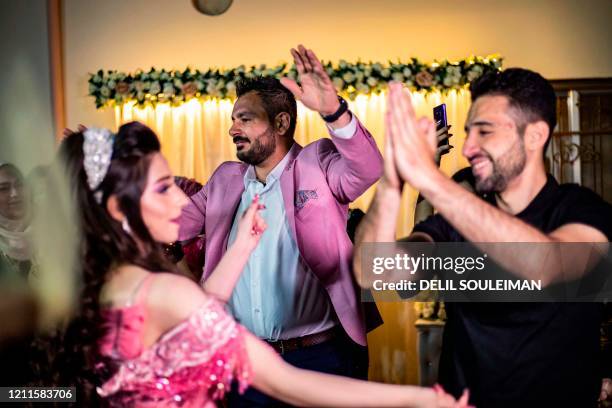 Syrian Kurdish couple Dilxwaz Ali and Arishan Ali dance with relatives during their engagement ceremony at home in the city of Qamishli in Syria's...