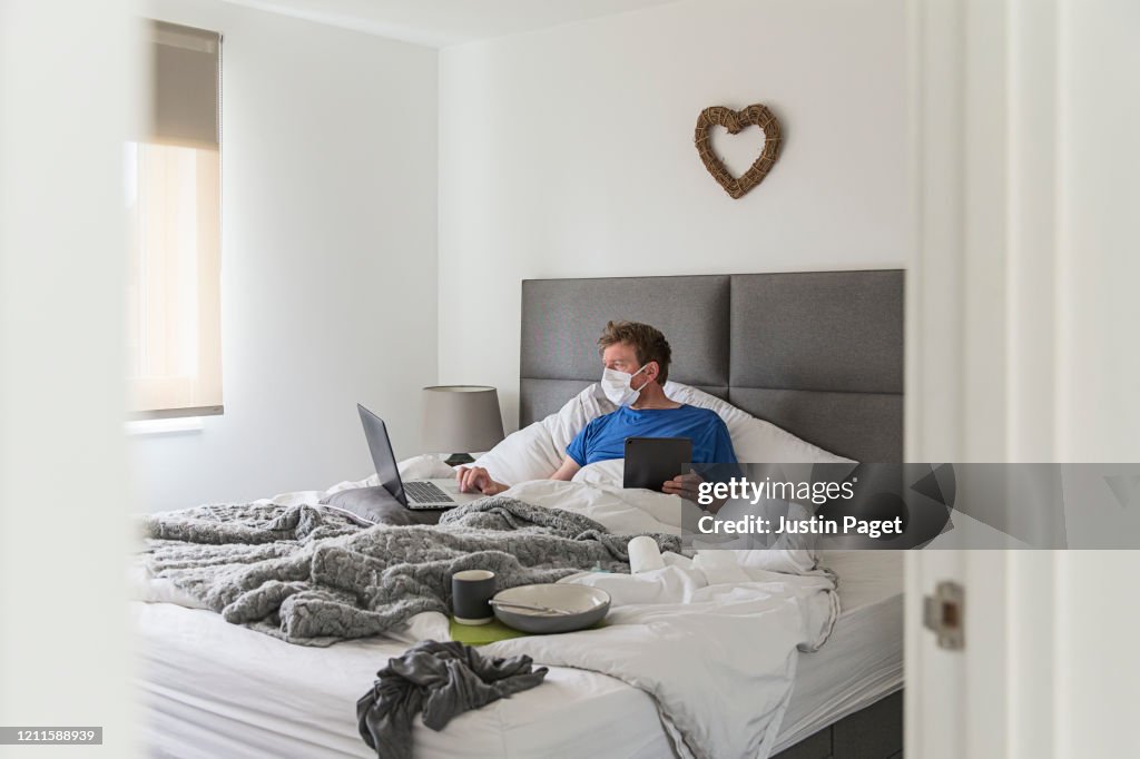 Man in self isolation in bed with the flu