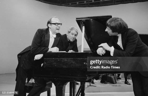 Comedians Eric Morecambe and Ernie Wise in a sketch with pianist Andre Previn for the BBC television series 'The Morecambe and Wise Show', December...