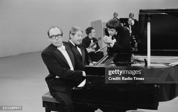 Comedians Eric Morecambe and Ernie Wise in a sketch with pianist Andre Previn for the BBC television series 'The Morecambe and Wise Show', December...