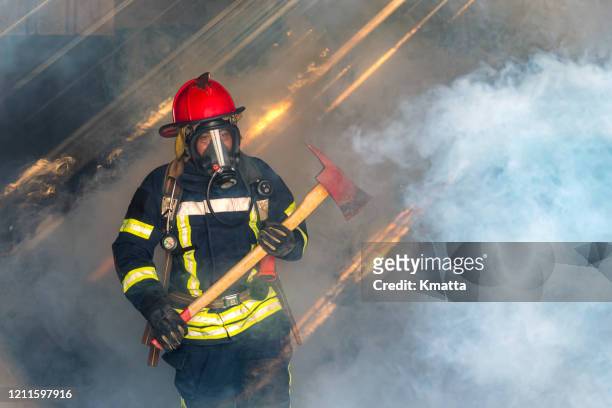 firefighters fighting a fire operation, fireman holding ax, - fireman axe stock pictures, royalty-free photos & images