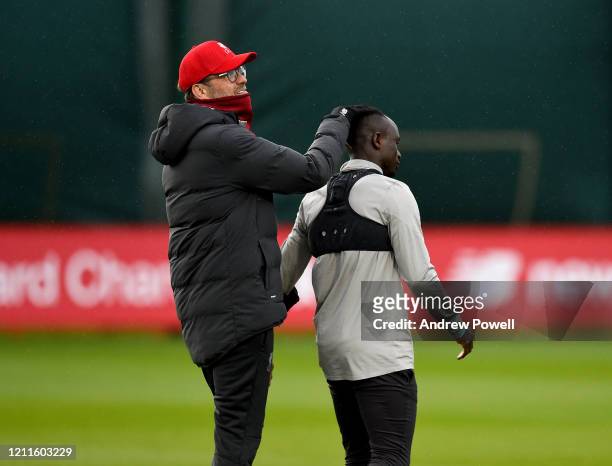 Jurgen Klopp manager of Liverpool with Sadio Mane during a training session at Melwood training ground on March 10, 2020 in Liverpool, United...