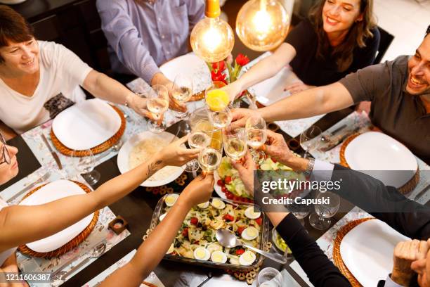 family toasting on dinner table - easter dinner stock pictures, royalty-free photos & images