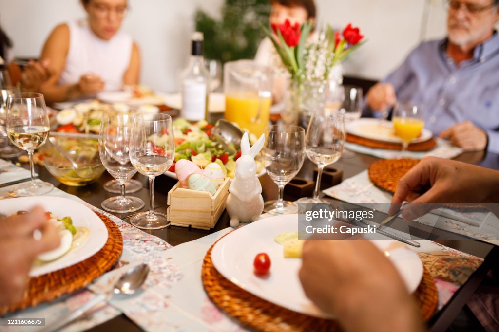 Família comendo juntas na mesa para a Páscoa