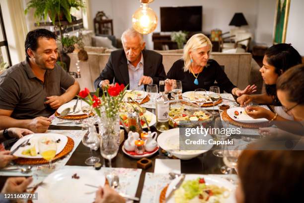 family eating together on table for easter - easter dinner stock pictures, royalty-free photos & images