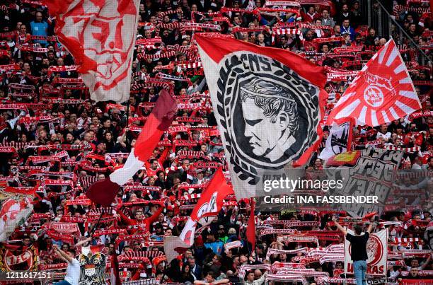 In this file photo taken on February 16, 2020 Cologne's supporters wave their flags during the German first division Bundesliga football match 1 FC...