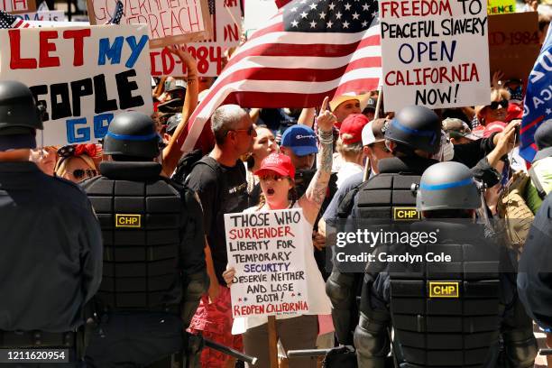 Officers dressed in riot gear prepare to remove protesters from the California Capitol grounds during a protest rally held on Friday, May 1, 2020....