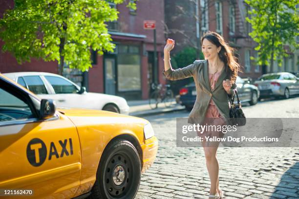 woman hailing and running for taxicab - hail stock-fotos und bilder