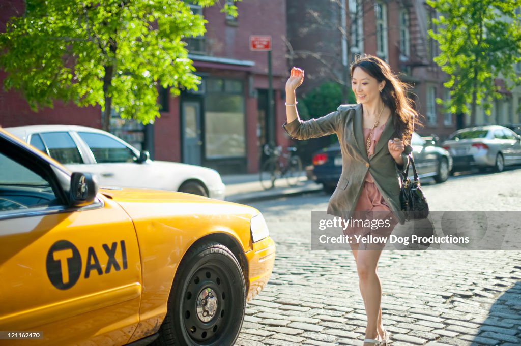 Woman hailing and running for taxicab