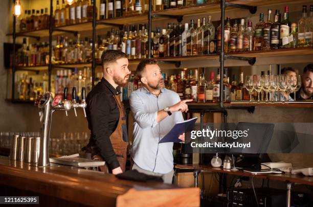 checking the stock in the bar - food and drink establishment stock pictures, royalty-free photos & images