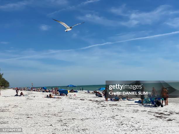 Sunbathers enjoy Sunset Beach in Treasure Island, Florida, on May 2, 2020. - Beaches in the city just south of Tampa are to be officially open on May...