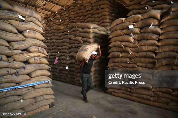 Laborer carrying sack of rice at a Regional Food Corporation on International Workers Day during a government-imposed nationwide lockdown as a...