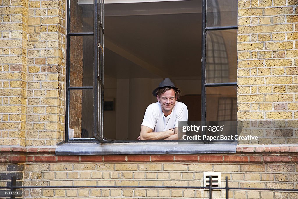 Young man looking out of his window