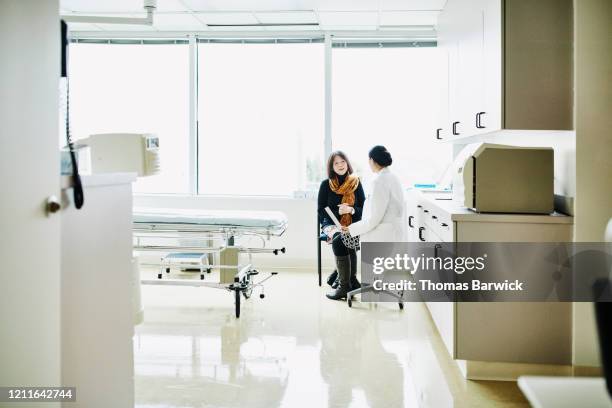 female doctor in discussion with senior female patient in exam room - medical examination room stock pictures, royalty-free photos & images