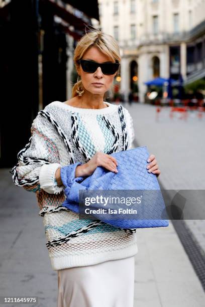 Influencer Gitta Banko, wearing a metallic-trimmed jaquard-knit sweater by Peter Pilotto, a white silk dress by Sly010, a indigo BV Twist bag by...
