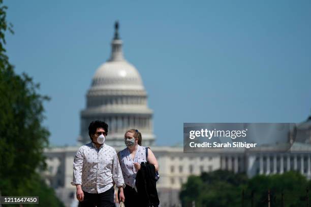 People wear protective masks as they spend time on the National Mall on May 2, 2020 in Washington, DC. Earlier in the day large groups of people...