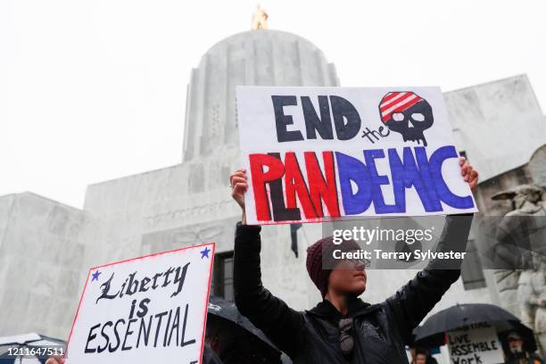 Protesters hold signs on the steps of the state capitol at the ReOpen Oregon Rally on May 2, 2020 in Salem, Oregon. Demonstrators gathered at the...