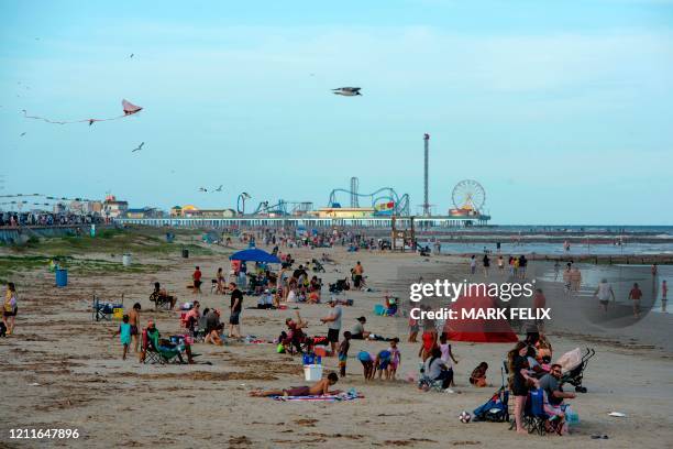 Beachgoers enjoy a day of sunshine at Galveston Beach on May 2, 2020 in Galveston, Texas, amid the coronavirus pandemic. - Texas beaches were ordered...