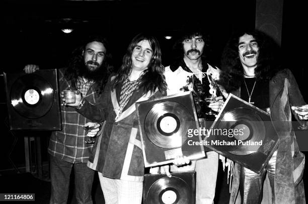 Black Sabbath pose for a group portrait with gold discs, London L-R Bill Ward, Ozzy Osbourne, Tony Iommi, Geezer Butler.