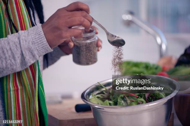 de hand die mangold salade van de vrouw kruiden. - strooisels stockfoto's en -beelden