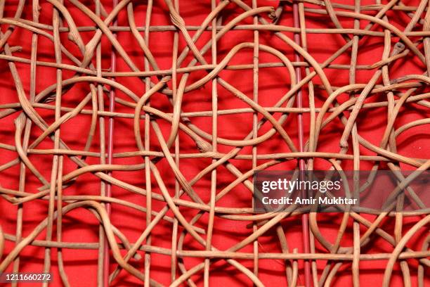 tangled flexible sticks on red background. - knooppatroon stockfoto's en -beelden