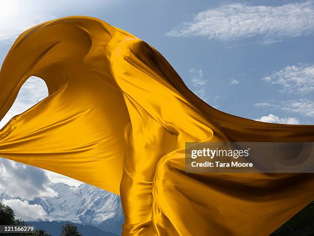 person covered in yellow material with mountains - fabrics stock pictures, royalty-free photos & images