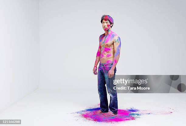 man covered in brightly colored powder - man splashed with colour fotografías e imágenes de stock