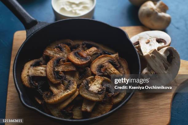 fried mushrooms in a vintage pan with fresh herbs - saute stock pictures, royalty-free photos & images