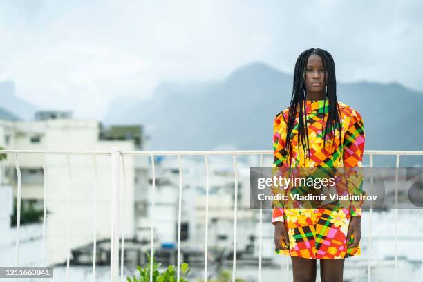 beautiful african woman standing on terrace in traditional dress - tunic woman stock pictures, royalty-free photos & images