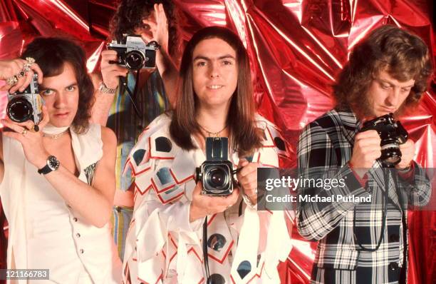 Slade, studio, group portrait, holding cameras, London L-R Jim Lea, Don Powell, Dave Hill, Noddy Holder.