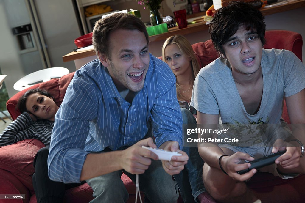 Men playing on computer game, women bored