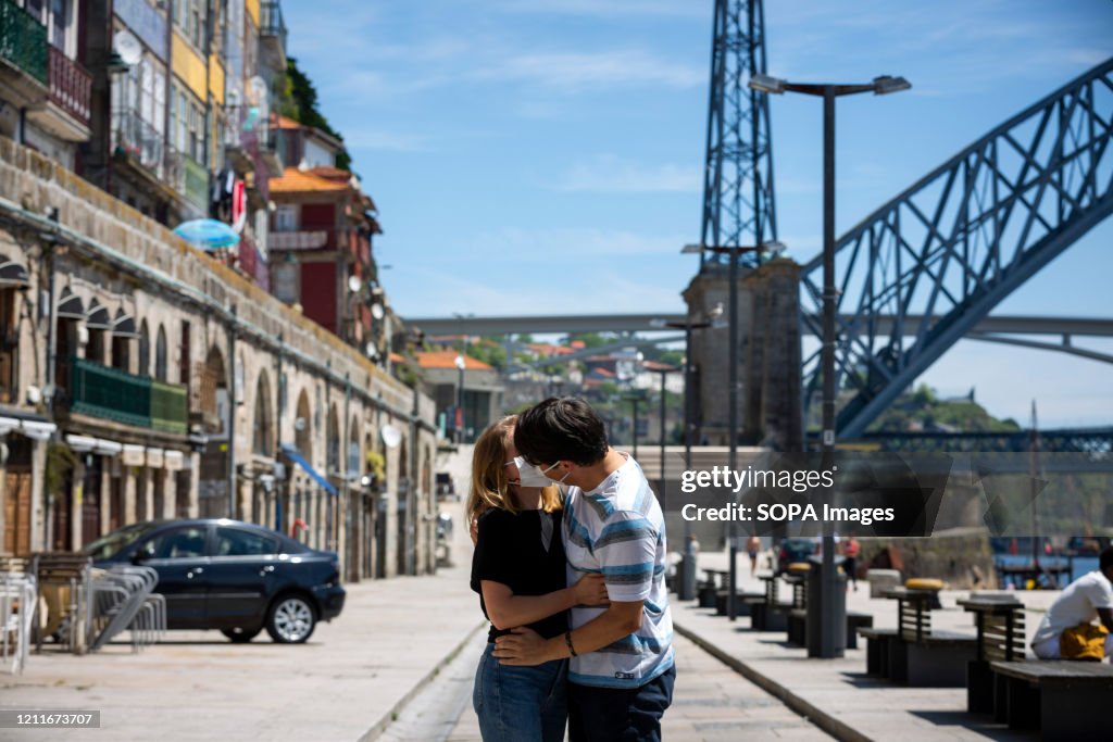 A couple kissing with face maks at the riverside tourist...