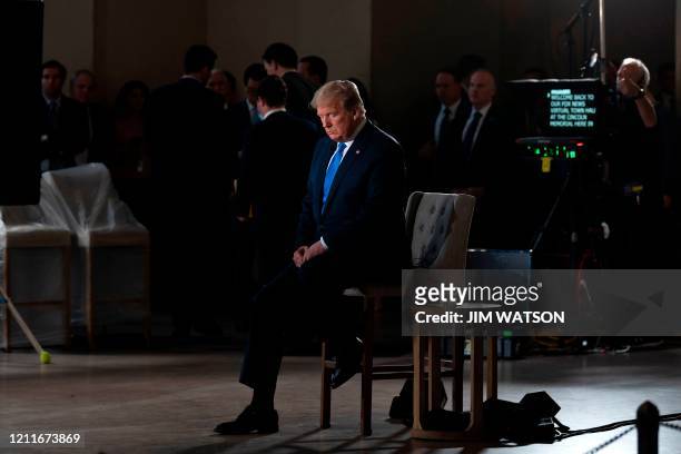 President Donald Trump gestures during a commercial break of a Fox News virtual town hall "America Together: Returning to Work," event from the...