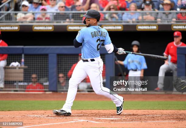 Carlos Gonzalez of the Seattle Mariners follows though on a swing against the Los Angeles Angels during a spring training game at Peoria Stadium on...