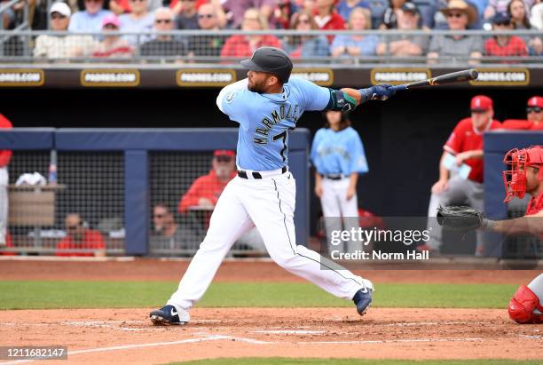 Jose Marmolejos of the Seattle Mariners follows through on a swing against the Los Angeles Angels during a spring training game at Peoria Stadium on...