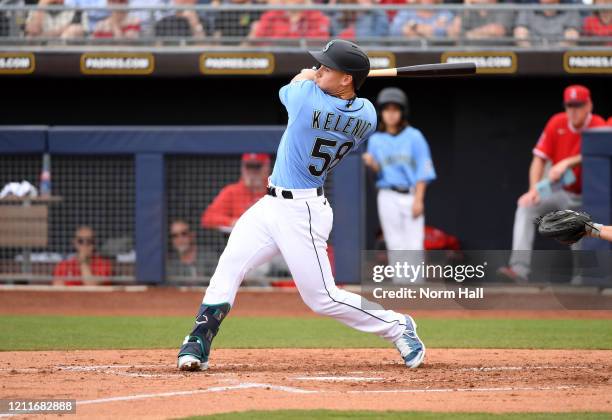 Jarred Kelenic of the Seattle Mariners follows through on a swing against the Los Angeles Angels during a spring training game at Peoria Stadium on...