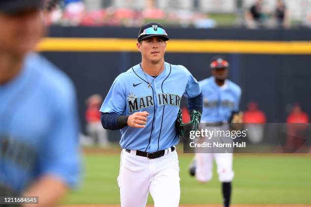 Dylan Moore of the Seattle Mariners runs to the dugout after the end of an inning against the Los Angeles Angels during a spring training game at...