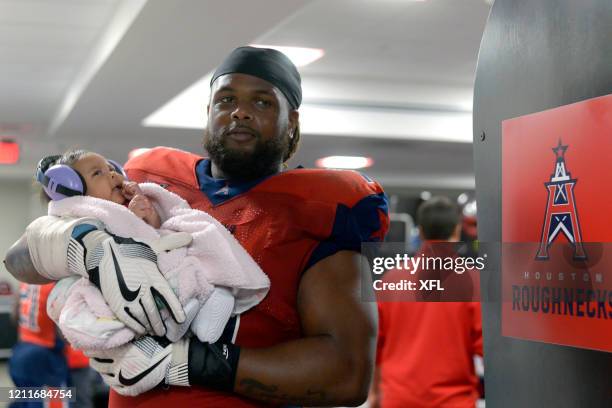 Terry Poole of the Houston Roughnecks brings his child into the locker room after the XFL game against the Seattle Dragons at TDECU Stadium on March...