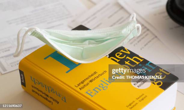 Face mask lies on a German-English dictionary during an English class at the Friedrich-Schiller-Gymnasium in Ludwigsburg, southern Germany, on May 4...