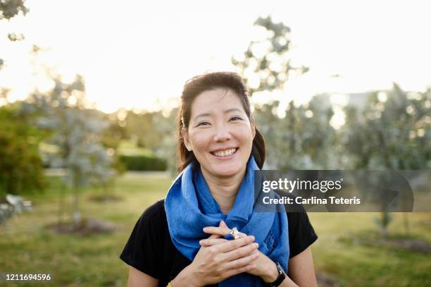 confident malaysian woman in a park - female laughing face stock pictures, royalty-free photos & images