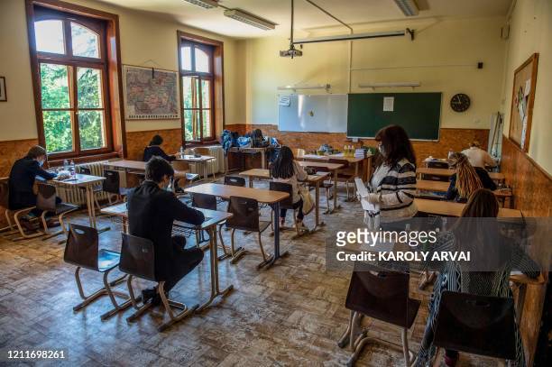 As everybody wears face masks in the classroom, a local teacher hands out the items of the writing exam in Szerb Antal Grammar Schools in Budapest,...